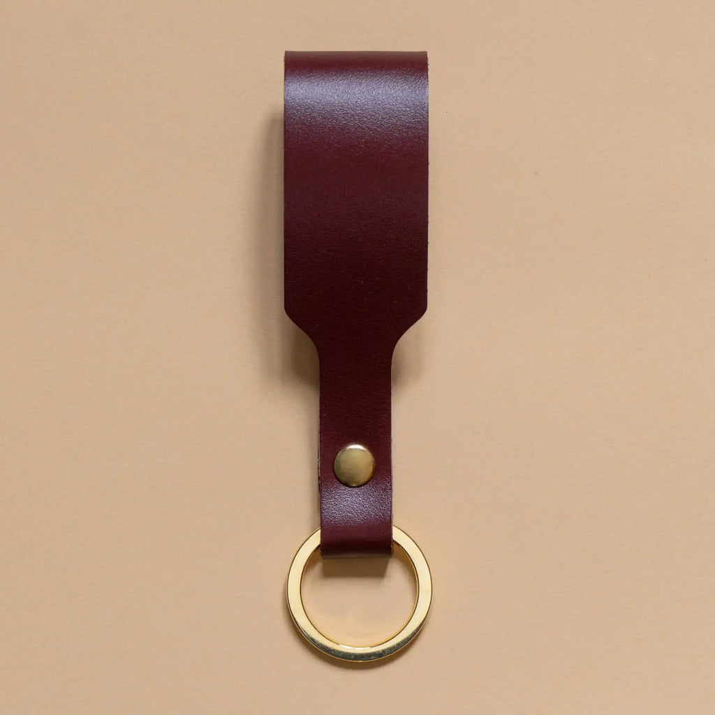 Schlüsselanhänger mit bordeauxroter Lederschlaufe und goldenem Ring aus Edelstahl