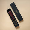 Bordeauxroter Schlüsselanhänger mit Lederschlaufe und goldenem Messing-Karabiner verpackt in schwarzer eleganter Geschenkschachtel