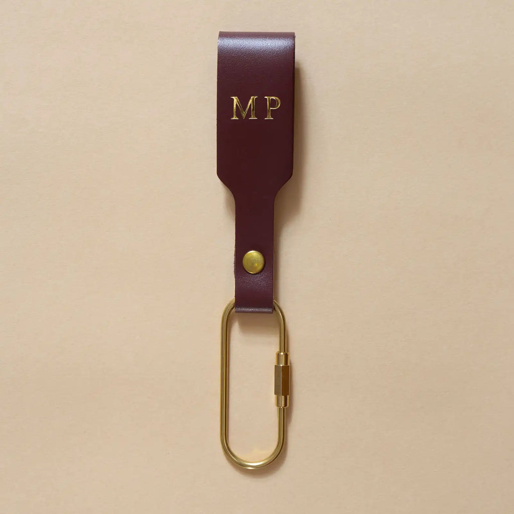 Bordeauxroter Schlüsselanhänger mit Lederschlaufe und goldenem Messing-Karabiner und goldener Prägung