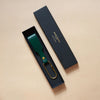 Tannengrüner Schlüsselanhänger mit Lederschlaufe und goldenem Karabiner in schwarzer Geschenkschachtel