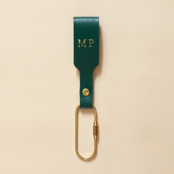 Tannengrüner Schlüsselanhänger mit Lederschlaufe und goldenem Karabiner und goldener Prägung
