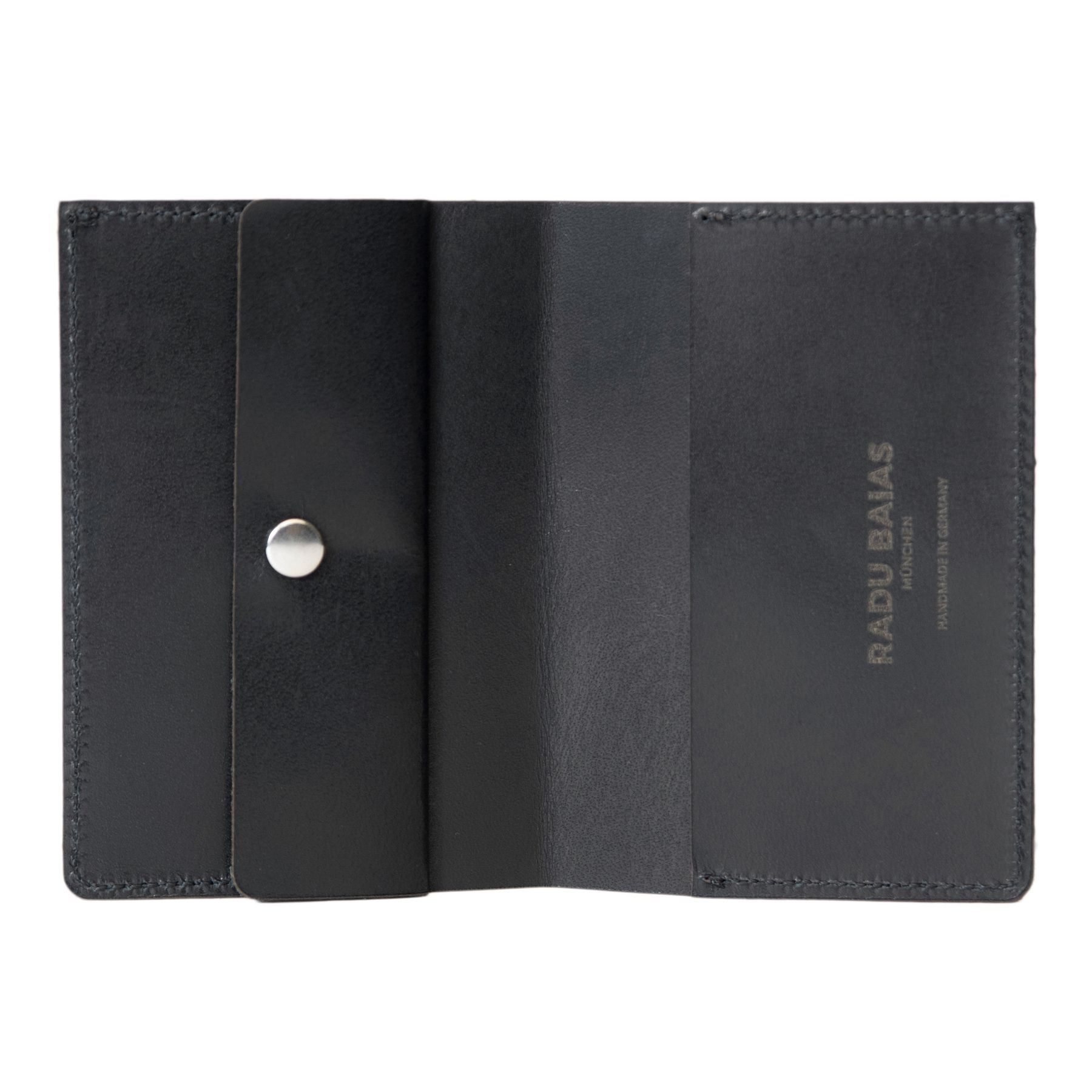 Aufgeklapptes Mini Portemonnaie in schwarz mit Münzfach, Druckknopf-Verschluss mit Logo-Gravur aus premium pflanzlich gegerbtem Leder