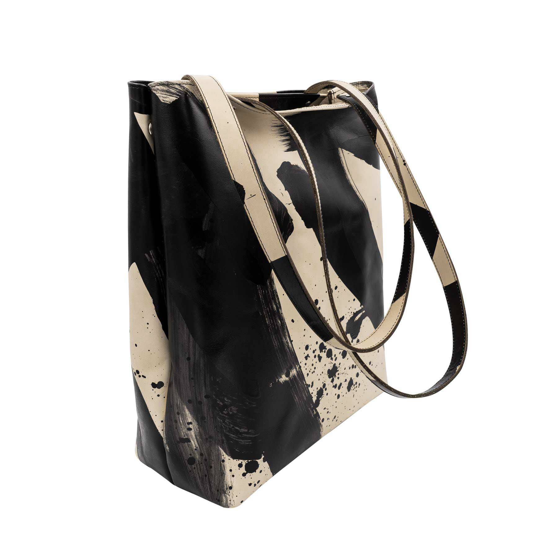 Schräge Ansicht eines abstrakt handbemalten Shoppers mit langen Henkeln in schwarz und beige von Radu Baias aus premium pflanzlich gegerbtem Olivenleder®